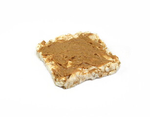 Puffed rice cakes smeared with peanut butter isolated on white. Stack of puffed whole grain crispbread isolated on white.