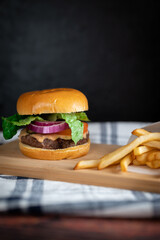 Homemade burger with fries on a rustic countertop