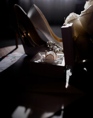 Front view of bridal wedding accessories. There are wedding heels, bouquet, rings in the box.