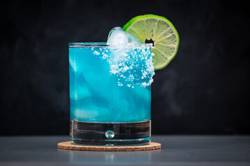 Blue Margarita on the rocks with salted rim and a lime wheel