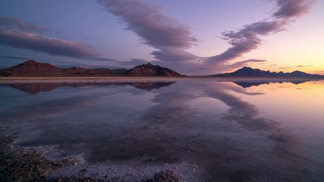 Time lapse of colorful sunrise reflecting over the Great Salt Lake as water covers the Bonneville Salt Flats in Utah.