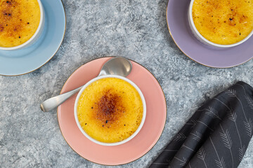 Creme Brûlée served in a white ramekin on beautiful pastel plates