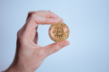 Fototapeta na wymiar Man's hand holding golden Bitcoin isolated on white background 