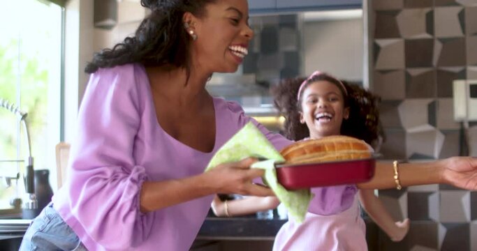Happy latinx family in the kitchen.mother and daughter preparing bread