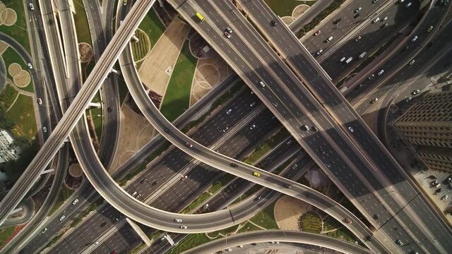 Aerial view of vehicles driving along Sheikh Zayed road with a complex and busy intersection right in Dubai downtown, United Arab Emirates.