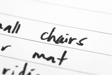 Macro shot of hand writing on paper using pen