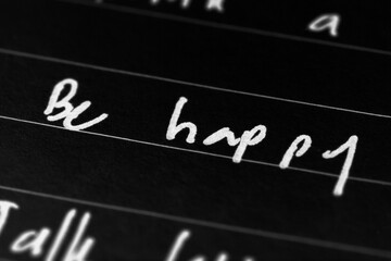 Macro shot of hand writing on paper using pen