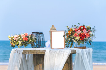 Romantic wedding ceremony setup on the beach with white photo frame for add text or photo.