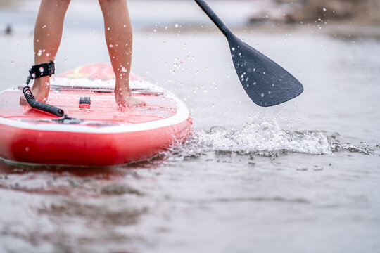close-up of legs Stand up paddle boarding on the river.