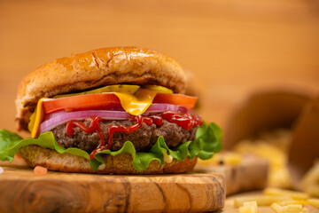 Hamburger or burger on a background with fries on a wood background