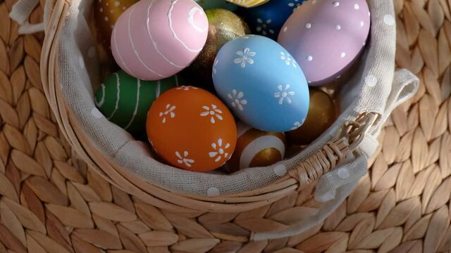 Easter colorful eggs in busket on white wooden table. Happy Easter background.