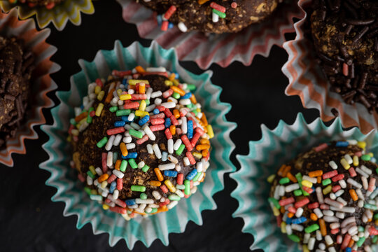 Closeup shot of rainbow sprinkle munchkins on paper muffin cups