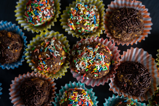 Closeup shot of rainbow sprinkle munchkins on paper muffin cups