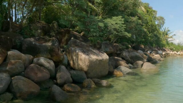 A Simple Wide Pan From Rocks To A Tropical Lagoon On A Sunny Day.