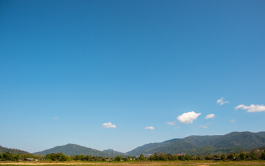 The white clouds have a strange shape and country side.Cloudy and blue sky.