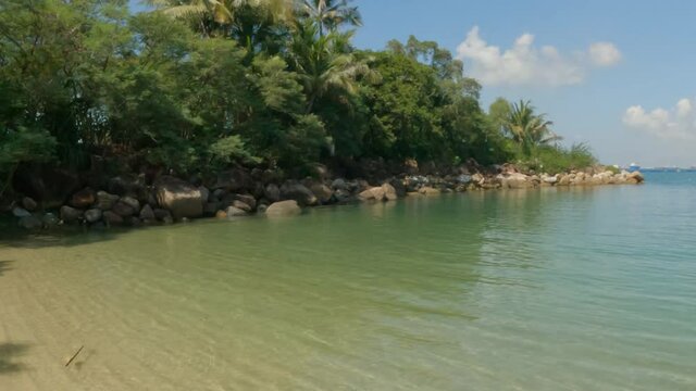 A Simple Wide Pan From Rocks To A Tropical Lagoon On A Sunny Day.