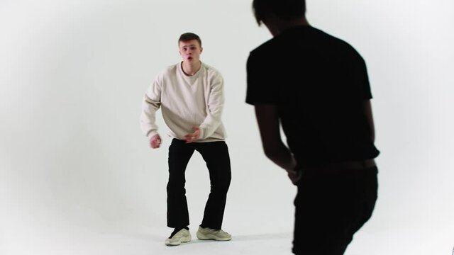 Young stylish man dancing on cyclorama - cameraman filming him