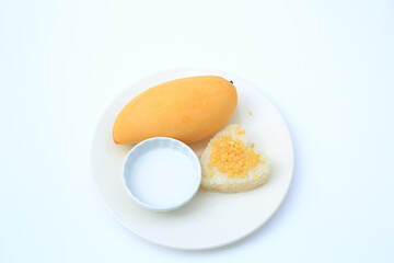 Sweet ripe golden mango and sticky with coconut cream on white circle ceramic plate isolated on white background