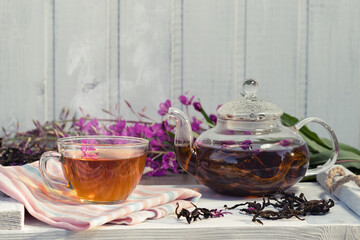 Herbal tea made from fireweed known as blooming sally in teapot and cup, copy space