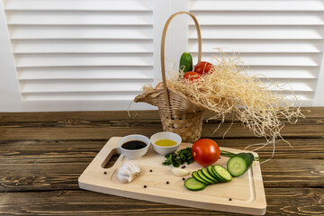 Tomatoes, cucumbers and avocado on the table and in a basket, olive oil and balsamic vinegar, garlic, vegetables, vegetarianism, healthy eating