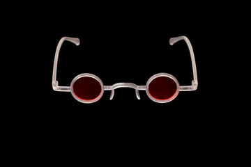 Extravagant glasses with red round glasses in white frame on black background. Creative and...