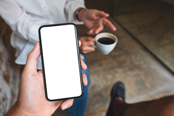 Mockup image of a man holding and showing mobile phone with blank  desktop screen to his friend while having conversation together