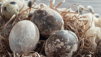 Easter composition - several marble eggs painted with natural dyes in a paper nest on the table