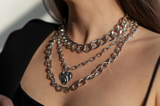 Beautiful model brunette in modern silver metal necklace, many chains