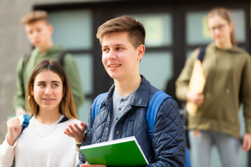 Obraz premium Cheerful teenage boys and girls walking together after lessons
