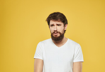 Obraz premium Brunette man gesturing with his hands on yellow background cropped view