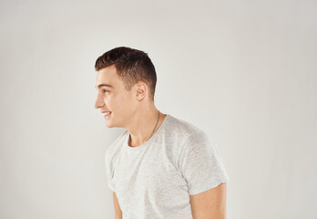 Man in white t-shirt emotions studio cropped view light background