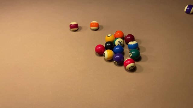 American Billiards break pool table close up under white light. Slow motion