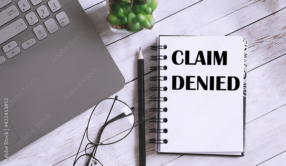Poster register claim denied text on notebook with office background