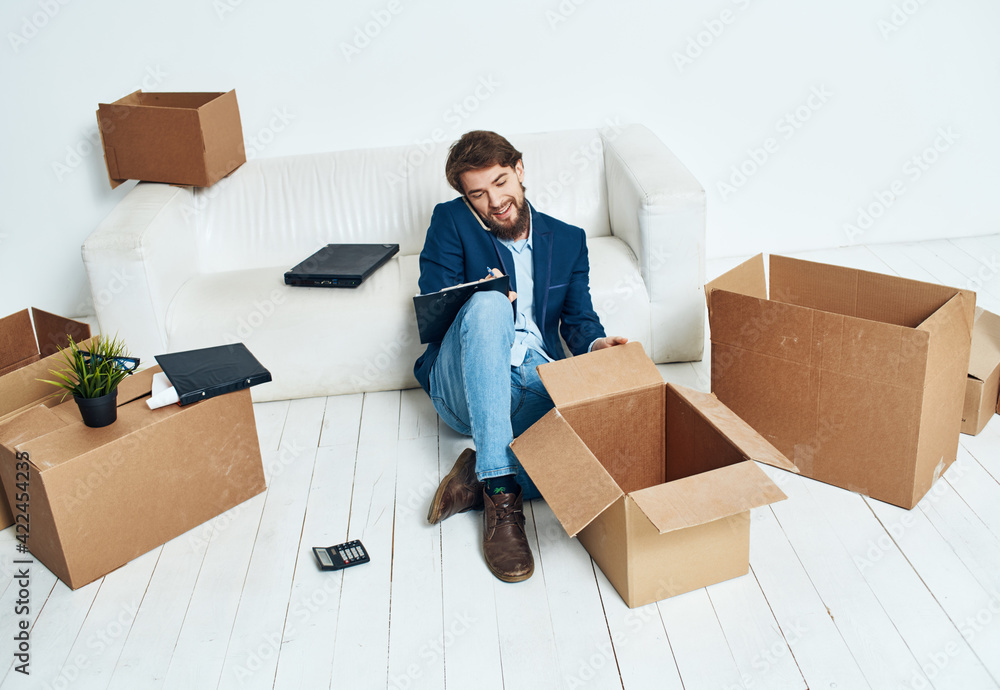 Wall mural business man near boxes with things unpacking moving to a new location office official lifestyle