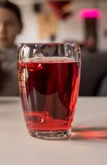 red cider in a glass goblet on the table, vertical.