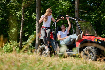 couple enjoying beautiful sunny day while driving a off road buggy