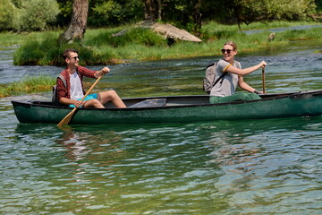 Fototapeta na wymiar friends are canoeing in a wild river