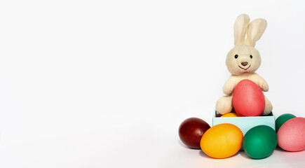 white plush bunny toy with painted easter eggs in gift box isolated on white background, holiday banner in pastel colors, Easter Day template with copy space