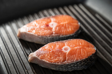 A Salmon fillet on a frying pan