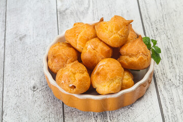 Sweet tasty profiteroles heap in the bowl