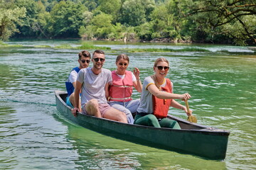 Group adventurous explorer friends are canoeing in a wild river