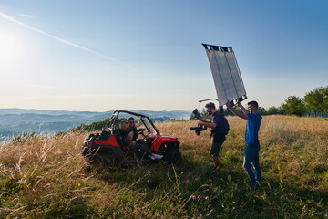 cameraman recording a young couple enjoying a buggy car ride up a mountain