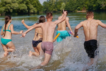 Fototapeta premium group of happy friends having fun on river