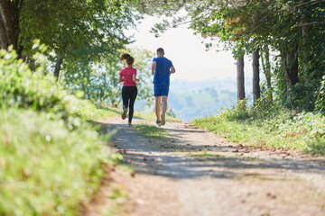 Obraz premium couple enjoying in a healthy lifestyle while jogging on a country road