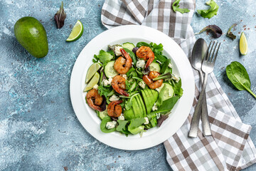 Food dieting concept. Green salad with avocado, blue cheese and smoked shrimps. Delicious breakfast or snack on a light background, top view