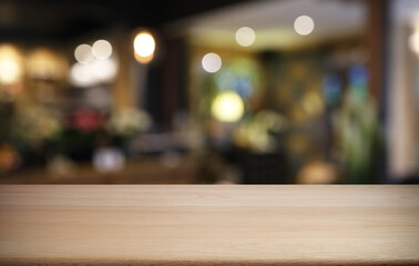 Empty wooden table in front of abstract blurred background of coffee shop . can be used for display or montage your products.Mock up for display of product