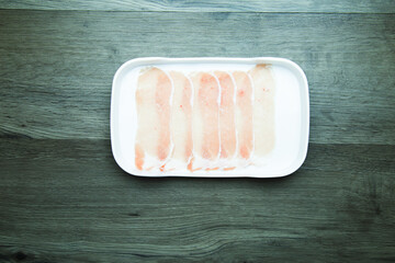 Obraz premium fresh raw pork, meat ,beef, belly, sliced on square plate on wood, wooden background,set shabu, hot pot ingredients.