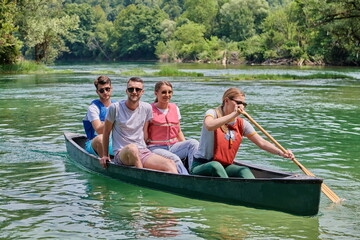 Fototapeta na wymiar Group adventurous explorer friends are canoeing in a wild river