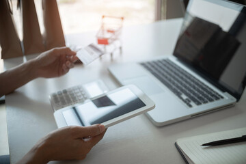 Young happy asian woman using credit card for online payment with laptop..