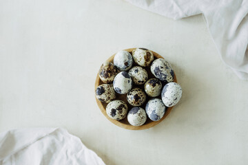 small spotted quail eggs with beige napkins on delicate beige table. vegan food, healthy protein....